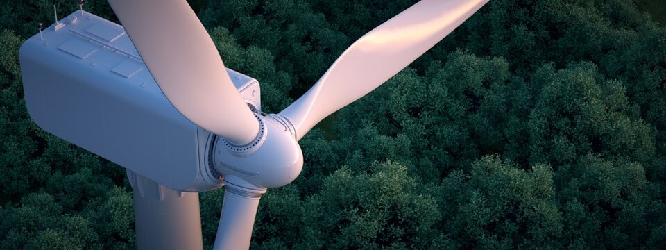 Close up of wind turbine with lush forest in the background. 