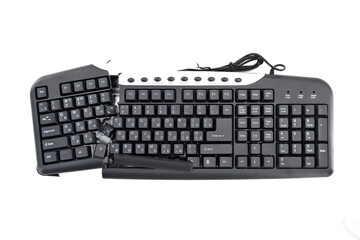 A broken keyboard divided into two parts lies isolated on a white background. Top view, close-up. Space for the text.. A keyboard without keys.