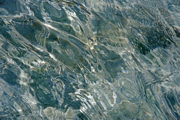 Full frame close-up view of the shiny reflecting clear water in a fountain pond