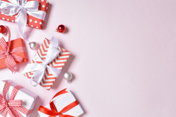 A bunch of red and white gifts on a pink background.