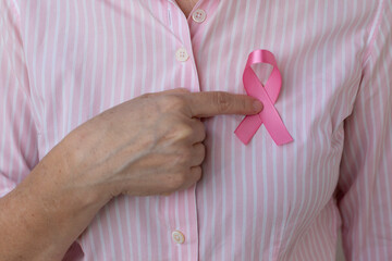 woman with pink ribbon on her chest. Breast cancer prevention campaign. pink October.