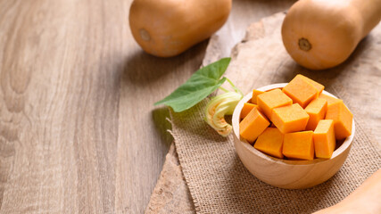 Sliced butternut squash in a bowl on wooden preparing for cooking