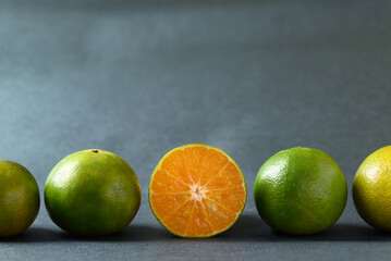 Fresh green tangerine fruit in row on color background