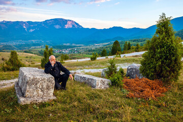 Old man and monumental, mistery, medieval tombstones, that lie across Bosnia and Herzegovina