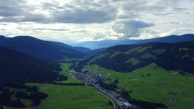 Camping and Villabassa, Dolomites, Puster Valley, Bolzano, South Tyrol, Italy, September 2021. Drone gradually descends while tracking north with a wide view of the mountainous landscape.