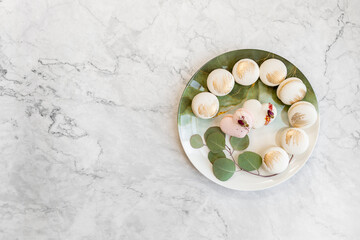 White macaroons are on a plate. Delicious light cookies on a plate on a light background. Bakery