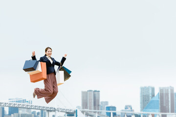 買い物袋を沢山持ってジャンプする女性（セール・爆買い）