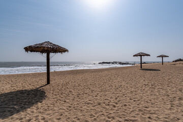 There are grass umbrellas on the beach in summer