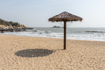 There are grass umbrellas on the beach in summer