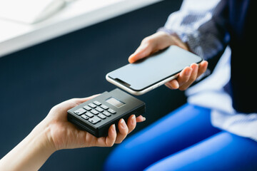 スマホ決済をする女性（手元・ボディパーツ・アップ）