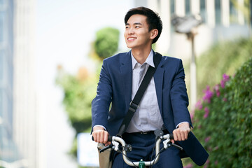 young asian business man commuting by bike in modern city