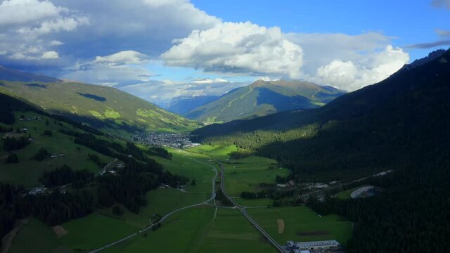 San Candido, Dolomites, Puster Valley, Bolzano, South Tyrol, Italy, September 2021. Drone gradually pulls west with a wide view of the densely forested mountainous landscape.