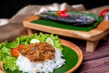 Sambal Peda, Indonesian Traditional Food in white bowl decorated with chiles and onion and garlic on wooden table and golden cloth
