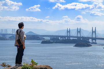 瀬戸大橋を眺める男性の後ろ姿　岡山県倉敷市　An Asian man standing and looking at the view of Seto Ohashi bridge at Setonaikai, Inland Sea of Japan, in Kurashiki city, Okayama pref. Japan 