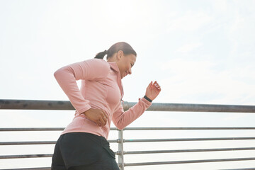 Young woman in sports clothing running in the morning outdoors