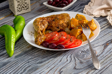 Stewed chicken leg and sweet potatoes (Ipomoea batatas) lie on a white plate close-up