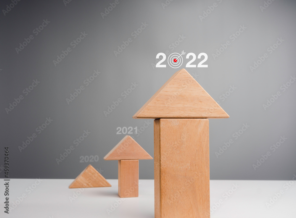 Aufkleber business chart rising up to year 2022. wooden blocks stacking as arrow up averages as a growth graph