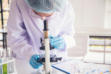 Woman scientist in lab look at science microscope medical test and research biology chemistry....