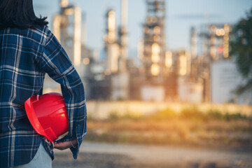 Refinery plant woman worker oil petrochemical industry hand holding red worker hard hat. Woman...