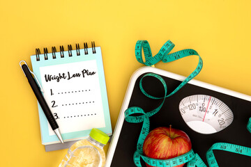 Weight scale and measure tape with fresh apple and notepad paper with handwriting motivation text Weight Loss Control , Healthy diet for weight loss control concept - 459374874