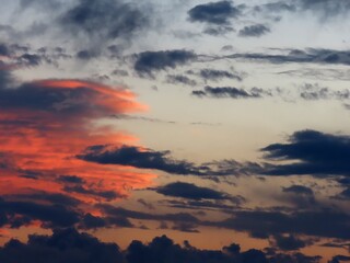 Bright clouds at sunset. Orange and dark gray clouds in the evening sky