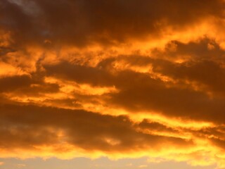 Bright orange evening sky with clouds. Summer sunset. Beautiful sky
