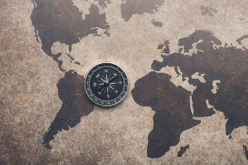Old compass on vintage world map