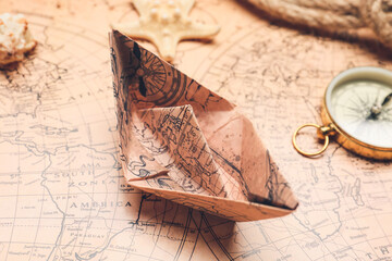 Paper boat on vintage world map