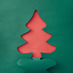 Colorful green Christmas tree paper cutout over sparkling white snow with copyspace for your holiday message or greeting in a creative handmade card