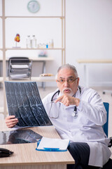 Old male doctor radiologist working in the clinic