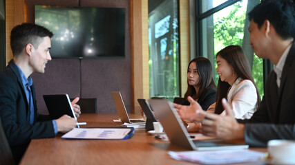 Executive businesspeople discuss corporation project planning in boardroom.