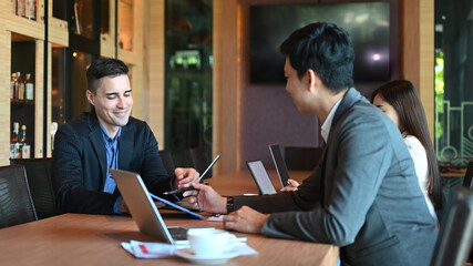 Corporate executives working together and discussing business plan in meeting room.