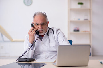 Old male doctor working in the clinic