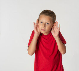 Young boy in red shirt hands to ears listening expression
