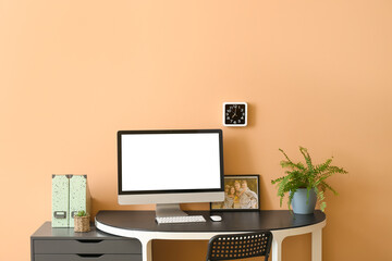 Modern workplace with computer near color wall