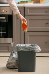 Woman throwing garbage in bag at home