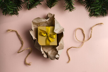 A small Christmas gift in a package of kraft paper and Christmas decor. top view
