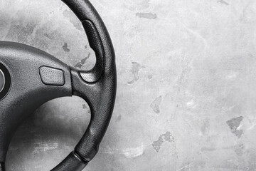 Modern steering wheel on grey background, closeup