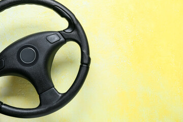 Modern steering wheel on yellow background