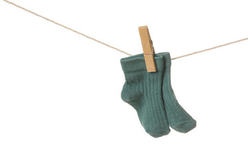 Baby socks hanging on rope against white background