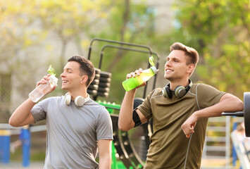 Obraz premium Young men drinking water on sport ground
