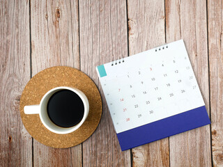 Obraz na płótnie Canvas Calendar with coffee cup on wooden texture background.