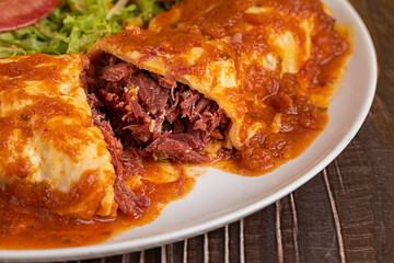 Dry meat pancake with dressing and salad