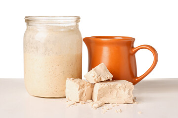 Jar with fresh sourdough and yeast on white background