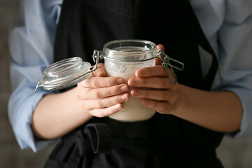 Woman with jar of fresh sourdough, closeup