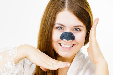 Woman applying pore strips on nose