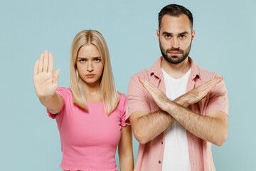 Young sad couple two friends family man woman in casual clothes showing stop palm hand gesture together isolated on pastel plain light blue color background studio portrait People lifestyle concept.