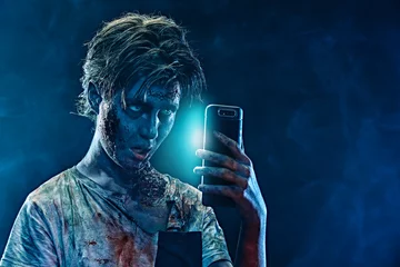 Fotobehang teen zombie with smartphone © Andrey Kiselev