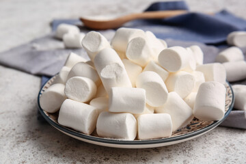 Plate with tasty marshmallows on light background