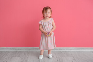 Cute baby girl near color wall